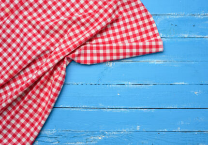 folded-red-white-cotton-kitchen-napkin-wooden-blue-background-top-view-copy-space